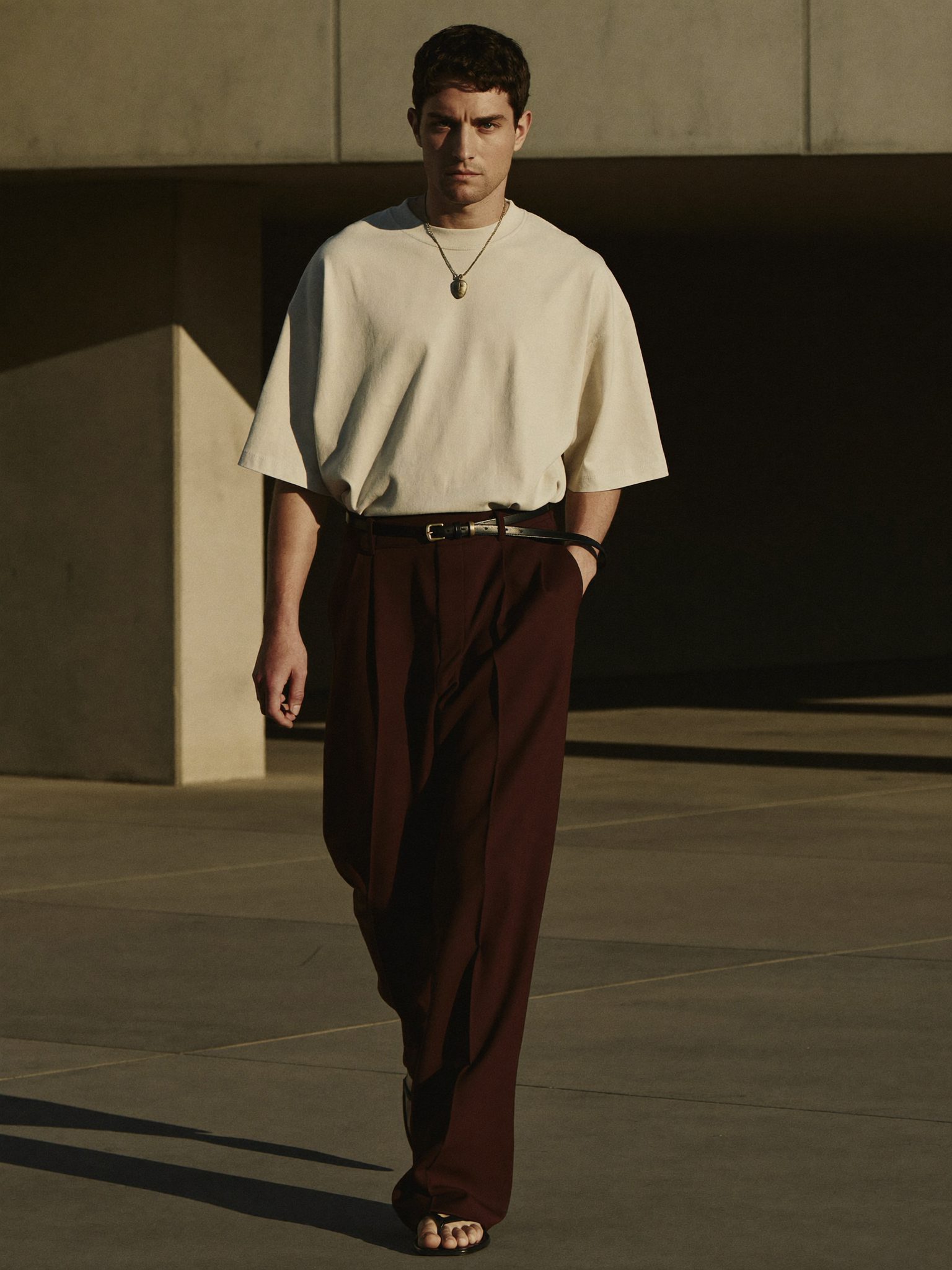 Calça espresso de pregas no concreto brutalista
