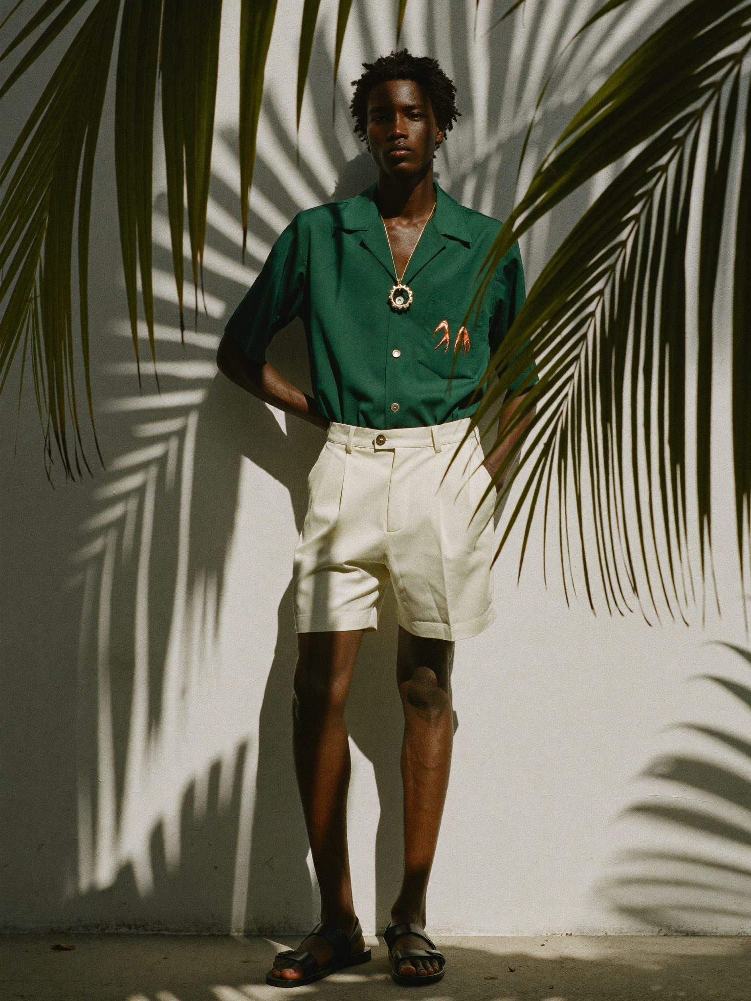 Camisa verde-mata entre sombras de palmeira